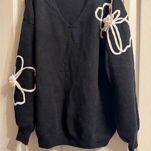 A Classy Chic Boutique Black V-Neck Sweater with White Floral Details